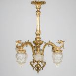 A large chandelier made of gilt bronze and glass and decorated with mythological figurines