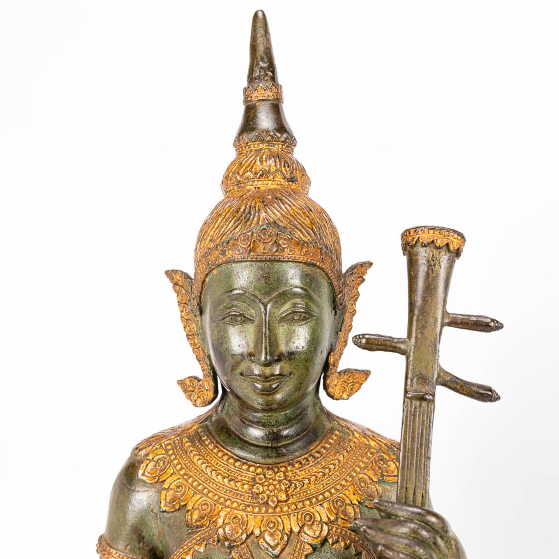 A collection of 2 oriental musical buddha's, made of metal. - Image 2 of 15