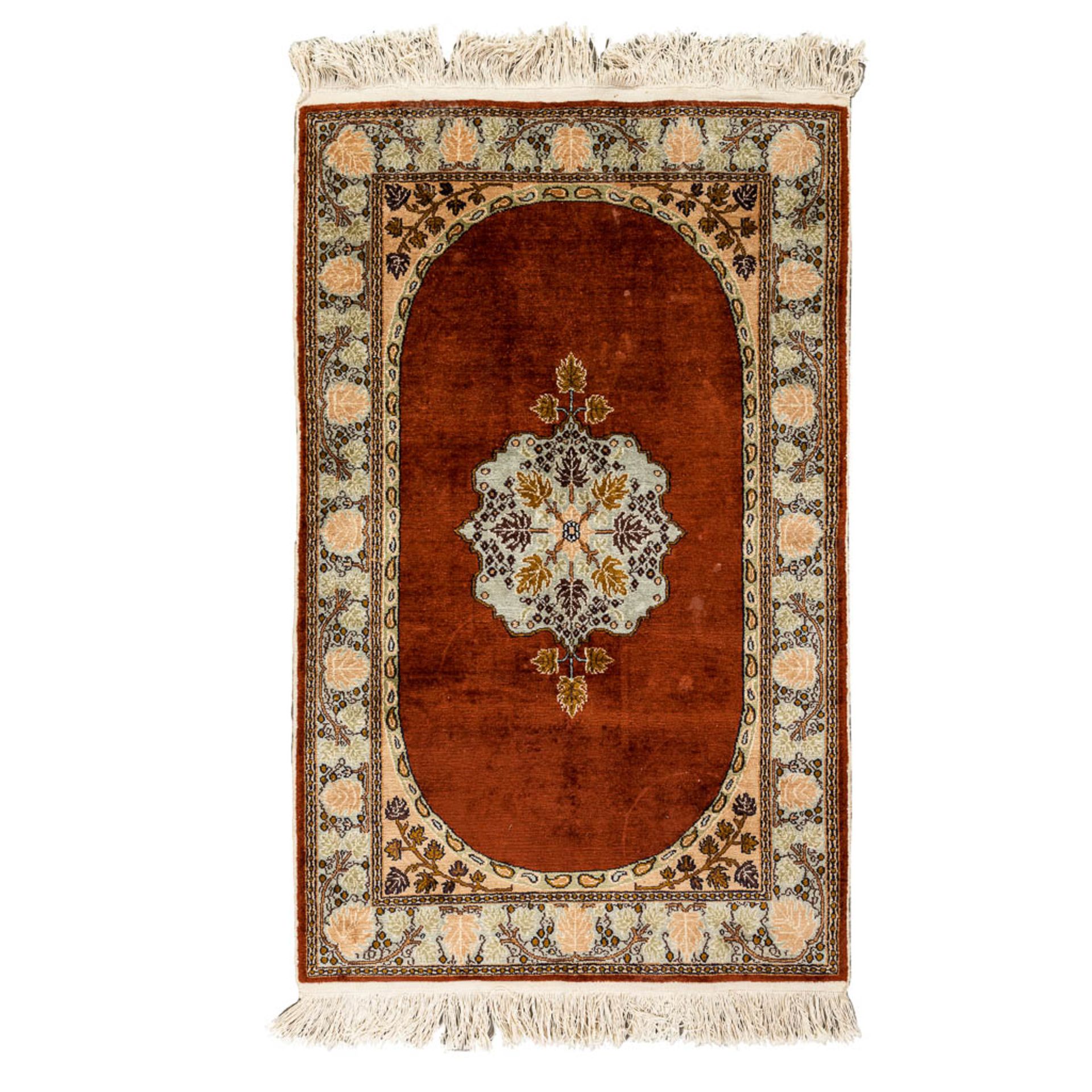 An oriental hand-made carpet. (79 x 125 cm)