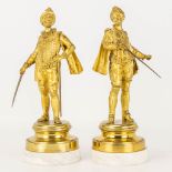 A pair of gilt Conquistadores statues made of gilt bronze and standing on a white marble base.