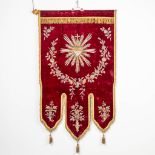 An embroidered banner with a 'Sacred Heart' image.