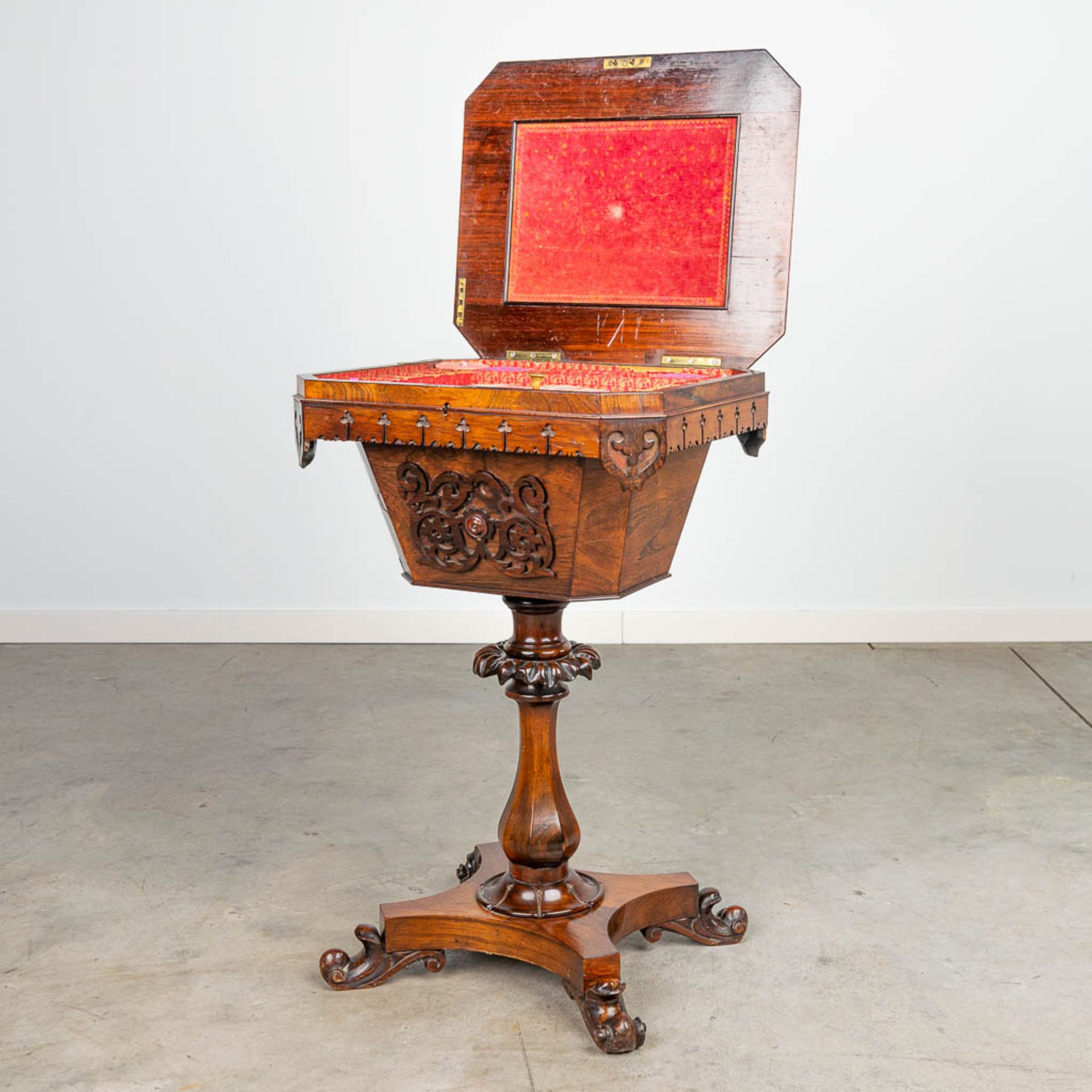 An antique sewing table 'Tricoteuse' decorated with wood sculptures.