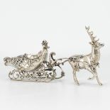 A reindeer with a sled, made of silver and marked