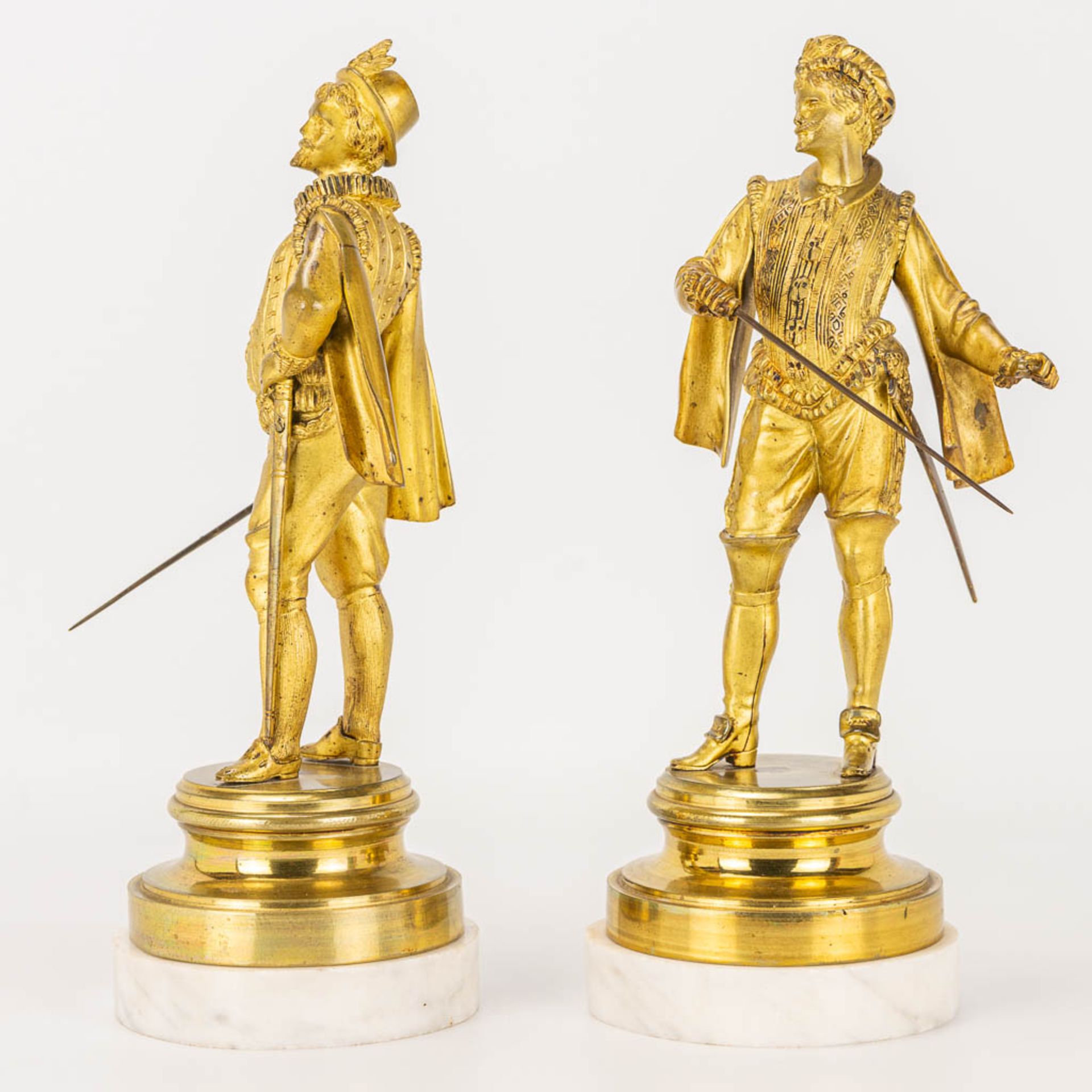 A pair of gilt Conquistadores statues made of gilt bronze and standing on a white marble base. - Image 5 of 9