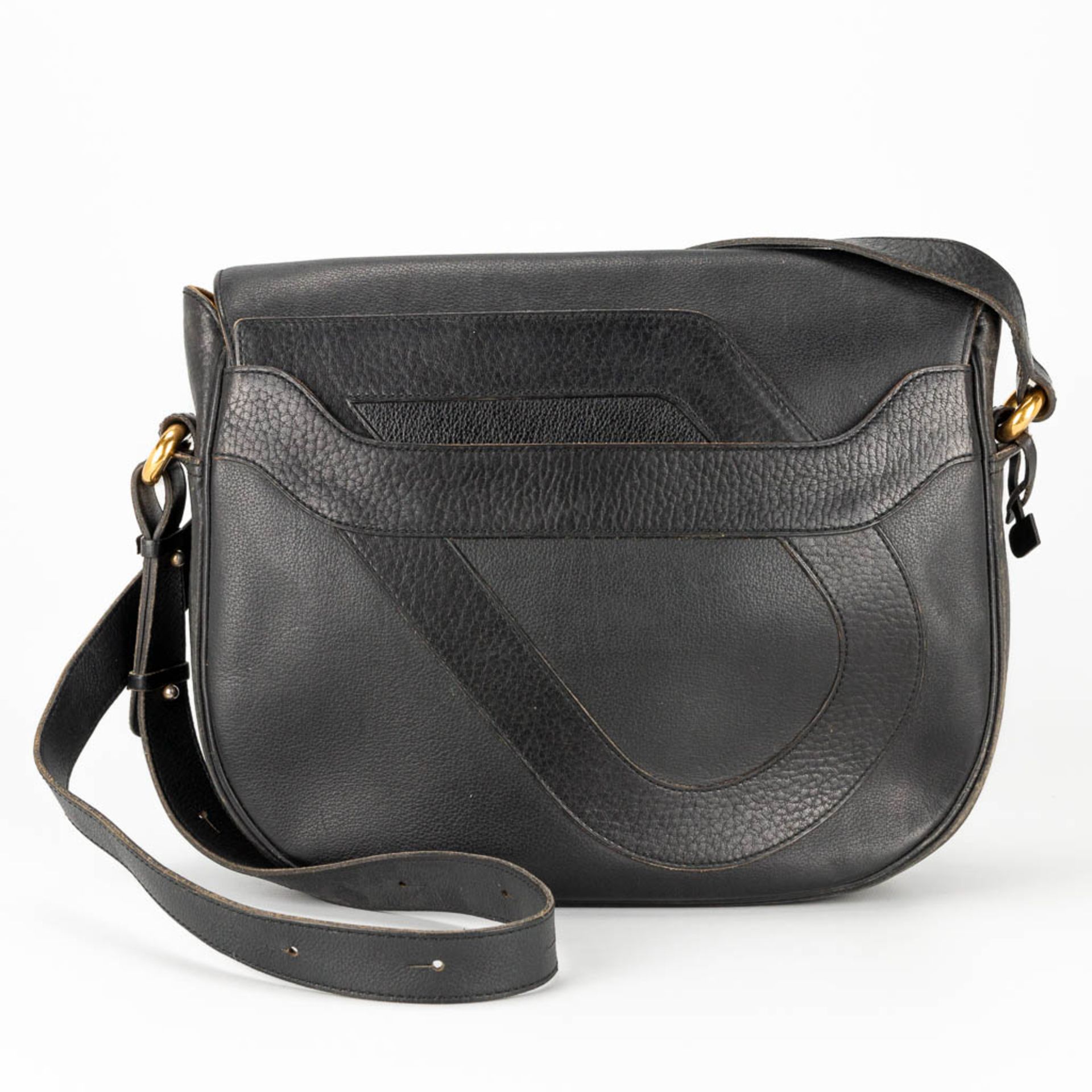 A purse made of black leather and marked Delvaux, with the original mirror.