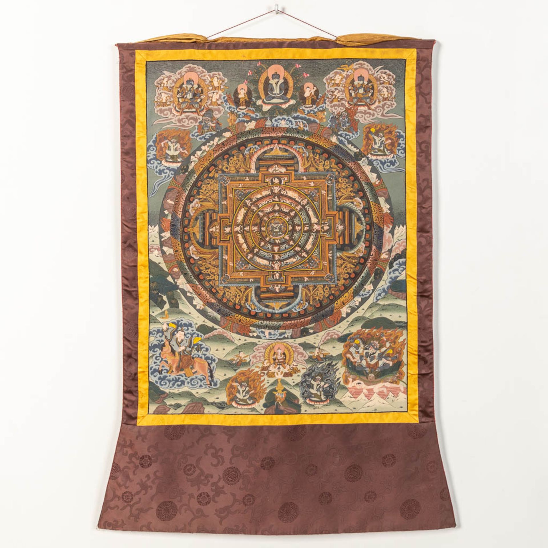 An Oriental Thangka, with hand-painted decor on a silk base.