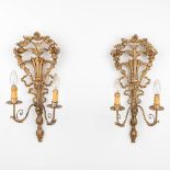 A pair of gilt wall lamps made of sculptured wood and stucco and marked 'Made in Florence, Italy'.