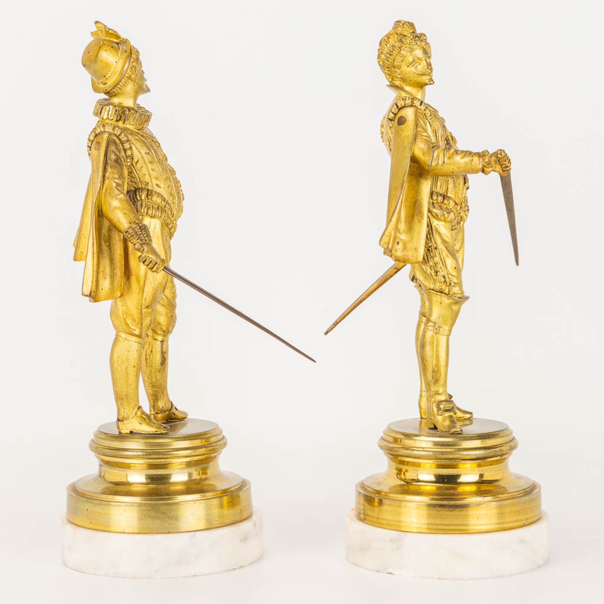 A pair of gilt Conquistadores statues made of gilt bronze and standing on a white marble base. - Image 4 of 9