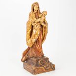 An antique wood sculpture of Madonna with a child, standing on a serpent.