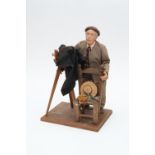 A Figure of a Photographer with a Mahogany & Brass Camera,