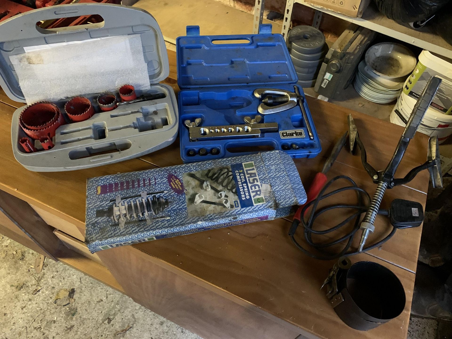 Various garage tools including flaring kit, coil spring compressors, holesaws, honing tool, piston