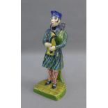 Early 19th century Portobello pottery figure of a Bagpiper, modelled standing wearing a tartan