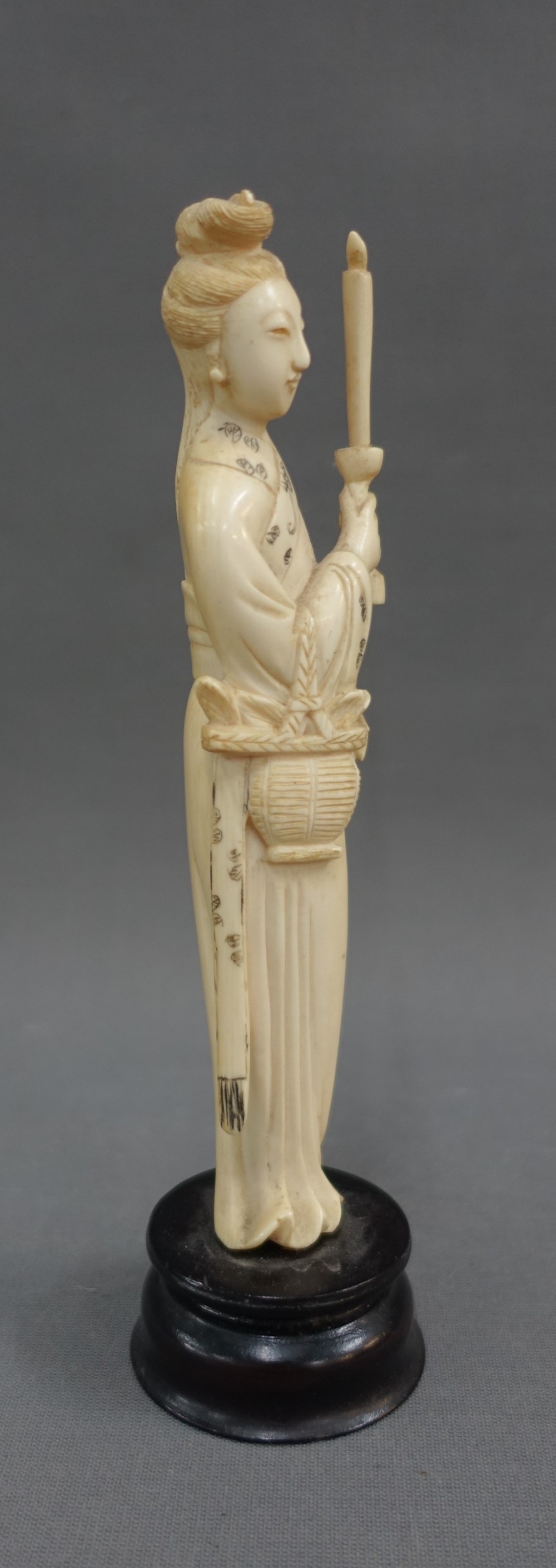 Early 20th century ivory okimono of a woman, modelled standing with a candle, on a wooden plinth - Image 2 of 4