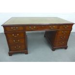 Mahogany veneered desk with green leather skivver and an arrangement of nine drawers with bracket