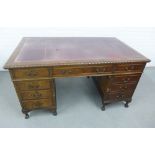 Mahogany desk with red leather skivver and arrangement of nine drawers on claw and ball feet, 80 x