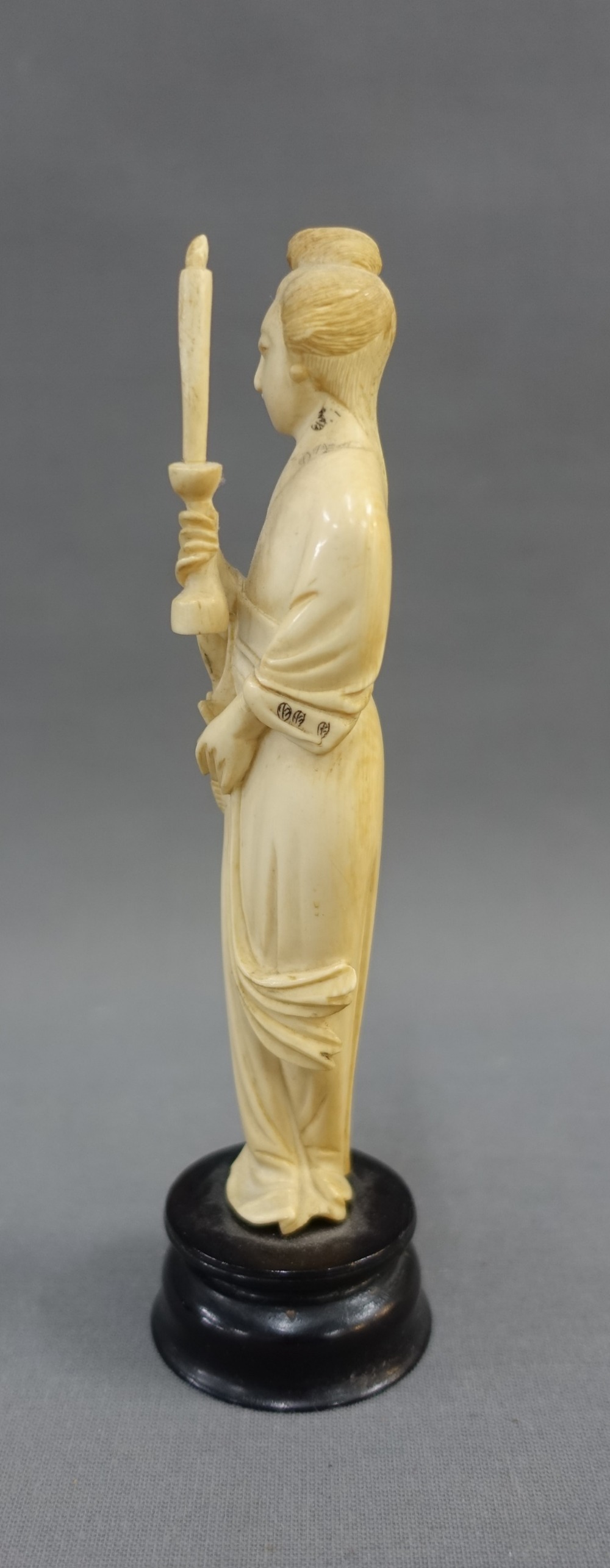 Early 20th century ivory okimono of a woman, modelled standing with a candle, on a wooden plinth - Image 4 of 4