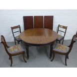 Mahogany extending dining table with circular top and three extra leaves together with a set of four