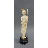 Early 20th century ivory okimono of a woman, modelled standing with a candle, on a wooden plinth