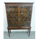 Mahogany bookcase with glazed doors and shelved interior on an associated mahogany base with