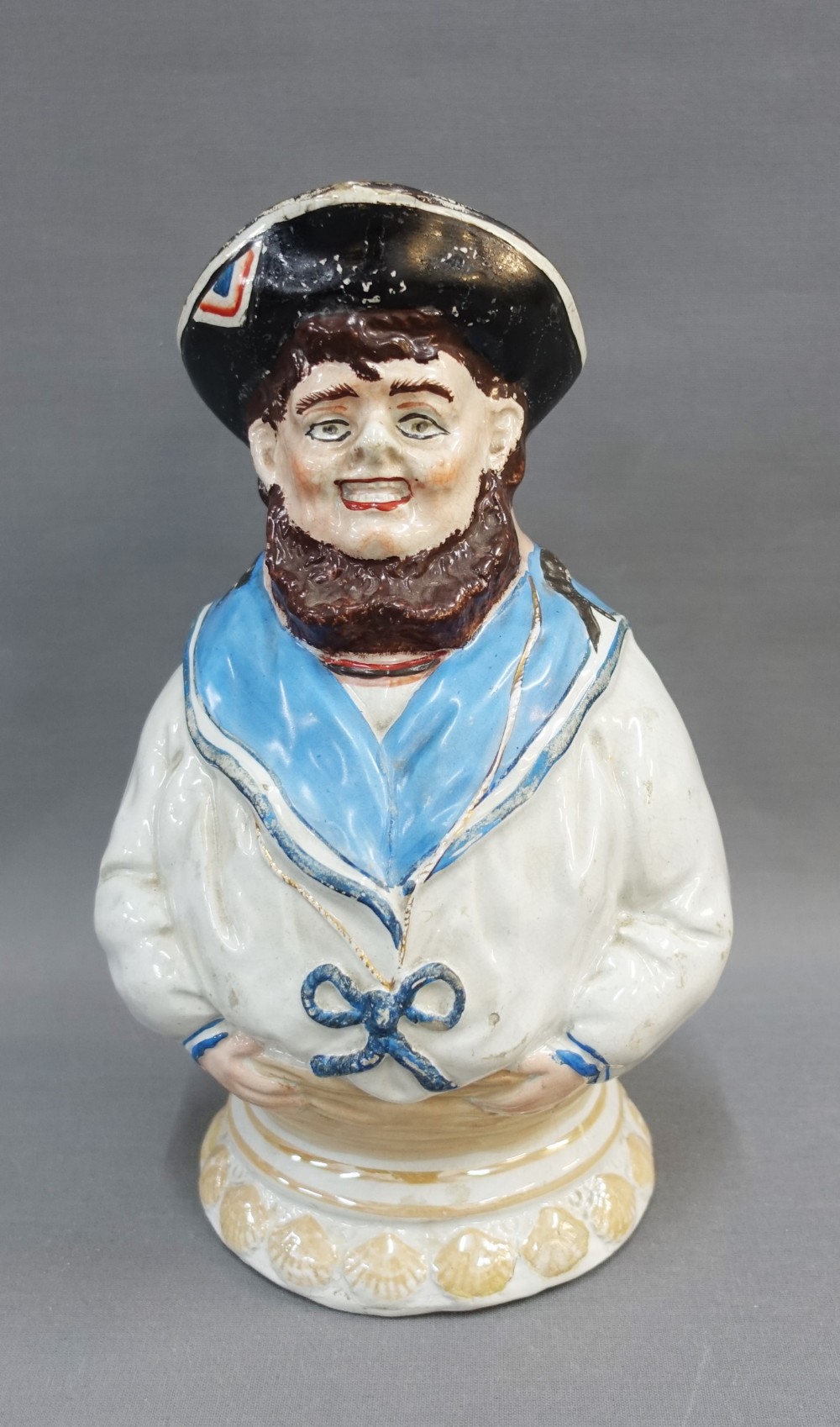 19th century Wemyss style Jolly Sailor moulded jug, with shell border, unmarked, 28cm high (a/f)