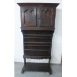 A dark oak dresser with a stepped cornice over a pair of foliate carved doors with a shelved