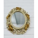 Oval wall mirror with pierced foliate frame with faux giltwood cherubs, 40 x 33cm