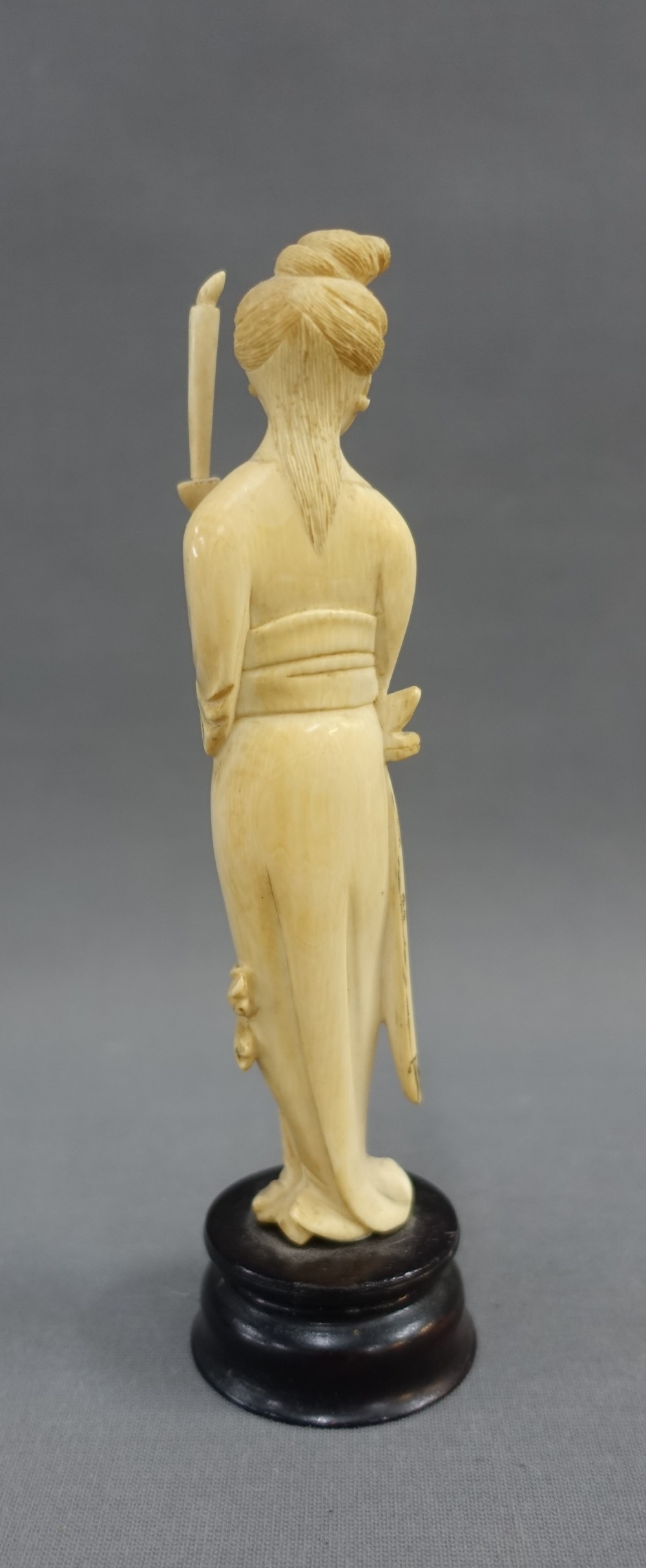 Early 20th century ivory okimono of a woman, modelled standing with a candle, on a wooden plinth - Image 3 of 4