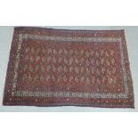 An Eastern rug, red field with allover scrolling pattern and multiple borders, 205 x 128cm