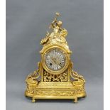 Gilt metal mantle clock with a silvered circular dial with Roman numerals on white shield plaques,