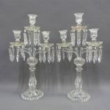 A pair of moulded glass candelabra, the scalloped drip trays with hanging lustres, 52cm high (2)