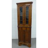 Oak two part corner cupboard, the top with a pair of glazed doors and shelved interior over a pair