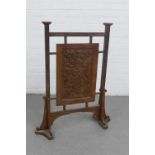 An oak Arts& Crafts screen, the central panel carved with thistles, on shaped side supports, 90 x