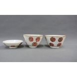 A pair of Chinese white glazed tea bowls with Shou motifs, comprising two cups and one saucer (3)