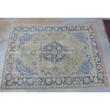 Large Persian design rug, the worn ivory field with central floral medallion, pale blue spandrels