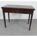 Oak fold over table with a single frieze drawer with brass handle, raised on square tapering legs,