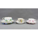 Two Meissen floral encrusted cups and saucers together with a Meissen floral painted cup and