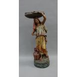 The Water Carrier, a painted plaster figure, 42cm high