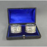 A pair of Victorian silver napkin rings, London 1897, in original leather case