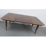 Victorian mahogany dining table, with two extra leaves, on turned legs with brass caps and