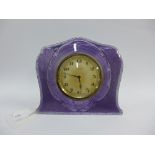 George V silver and lilac enamel clock, the silvered eight day dial with Arabic numerals, with easel