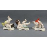 Three Continental porcelain cherubs, on rococo style bases, with blue crown and K printed