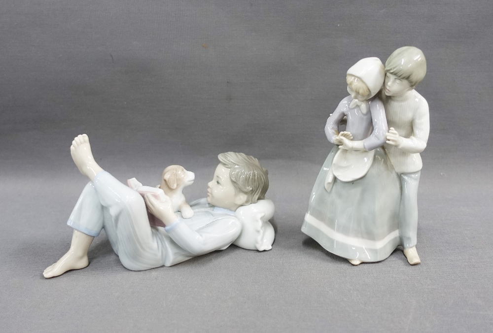 Lladro figure of a boy, modelled lying down and reading with his puppy, 18cm, together with