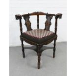 Corner chair, the arms with carved lion heads, upholstered seat and raised on fluted and ring turned