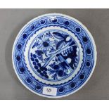 Tin glazed plate with floral pattern and a blue dot border, fritting to the rim, 24cm diameter