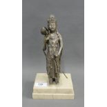 Eastern white metal figure of an Immortal, likely Tibetan, modelled standing and holding a lotus