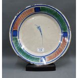 Tin glazed charger, with leaf design to centre within blue, red and green sponged border, on a