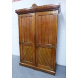 Mahogany Gothic wardrobe with a shaped cornice over a pair of panelled doors with brass strapwork