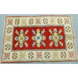 Turkish rug, with a central red panel containing three leaf and flowerhead medallions, within an