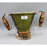 An unusual early brass loving cup with turned wooden handles and circular wooden base, 32cm wide