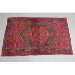 Eastern rug, the red field with a central panel with serrated edges, 130 x 220cm